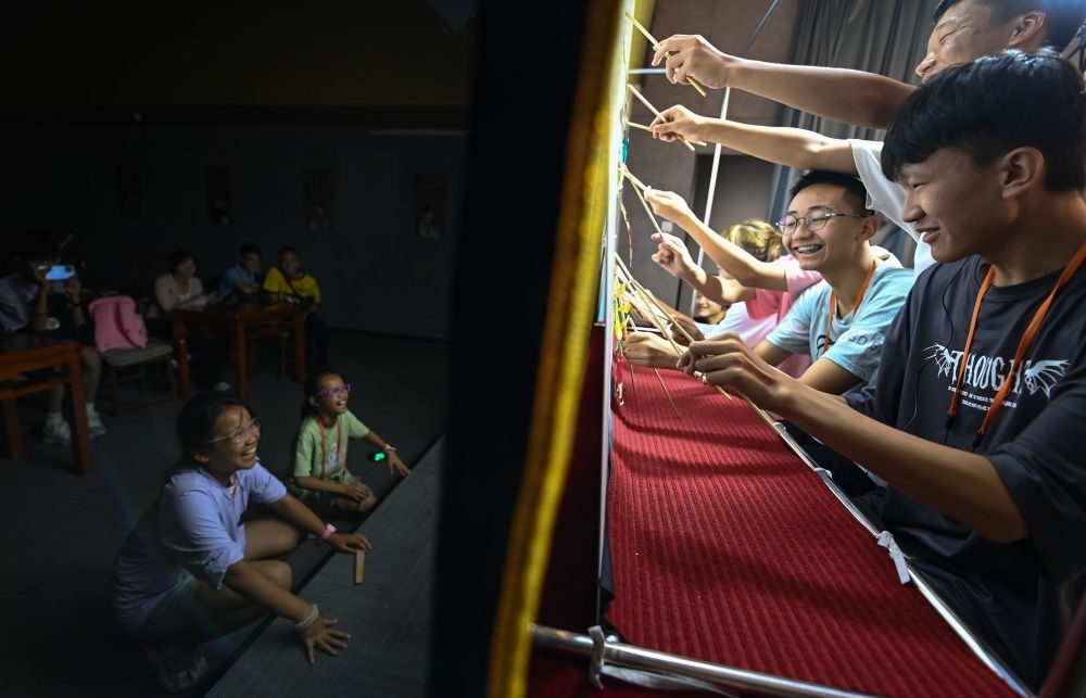 2023年8月8日，進(jìn)行暑期研學(xué)的學(xué)生在位于陜西省西安市的中國秦腔藝術(shù)博物館體驗皮影戲演出。新華社記者 鄒競一 攝