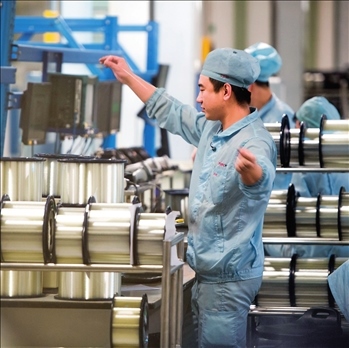 在位于武漢的長飛光纖光纜股份有限公司光纖生產(chǎn)車間內(nèi)，工作人員對光纖進(jìn)行檢測（資料圖片）。肖藝九攝/本刊