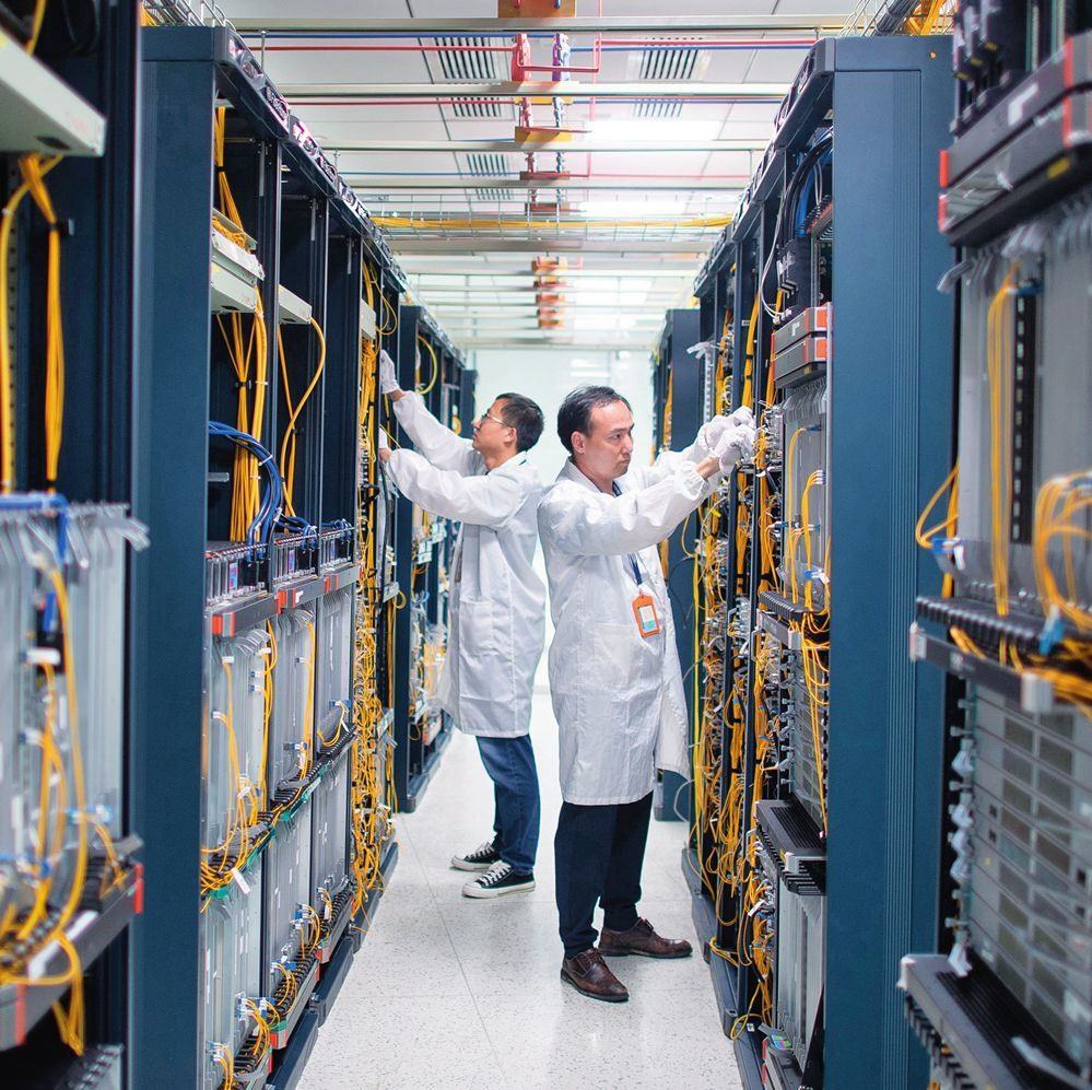 在位于武漢中國光谷的光電器件研發(fā)制造商——武漢光迅科技股份有限公司生產(chǎn)車間內(nèi)，技術(shù)人員在光模塊生產(chǎn)線作業(yè)（2023年4月11日攝）。程敏攝/本刊