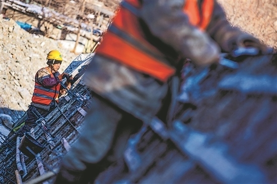 1月3日，房山區(qū)，工人正在雙泉河修筑堤壩。