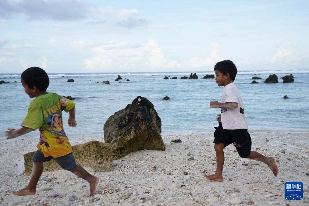 1月20日，兒童在瑙魯海邊嬉戲。新華社記者 王申 攝