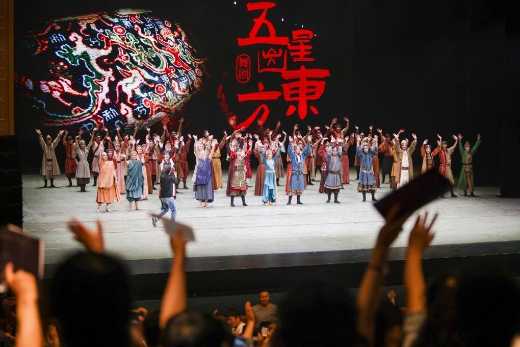 2023年7月31日，新疆和田地區(qū)新玉歌舞團(tuán)在烏魯木齊京劇院演出舞劇《五星出東方》后和觀眾互相揮手致意。這場演出是第六屆中國新疆國際民族舞蹈節(jié)的參演劇目之一，曾榮獲國家“文華獎(jiǎng)”等。新華社記者 郝昭 攝