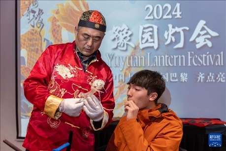 1月28日，在上海豫園舉行的民俗活動(dòng)上，美國(guó)馬斯卡廷中學(xué)學(xué)生在非遺傳承人的指導(dǎo)下吹糖偶。 新華社記者 王翔 攝