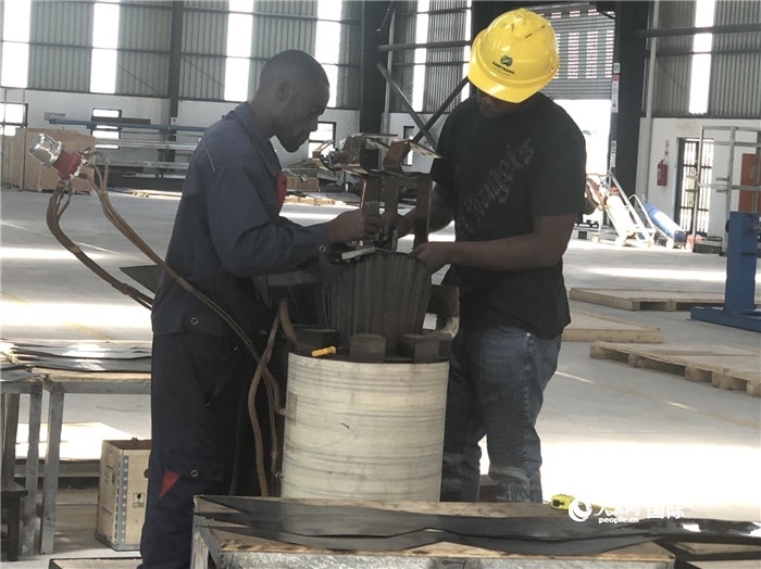 經(jīng)貿(mào)合作區(qū)廠房內(nèi)，當(dāng)?shù)毓と苏诰o張作業(yè)。人民網(wǎng)記者 黃培昭攝