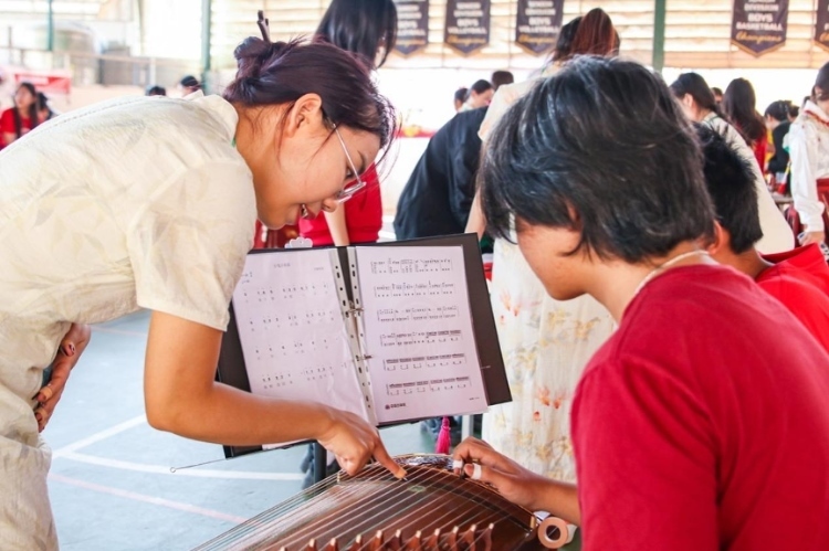 志愿者教師指導(dǎo)學(xué)生彈奏古箏?；顒?dòng)主辦方供圖