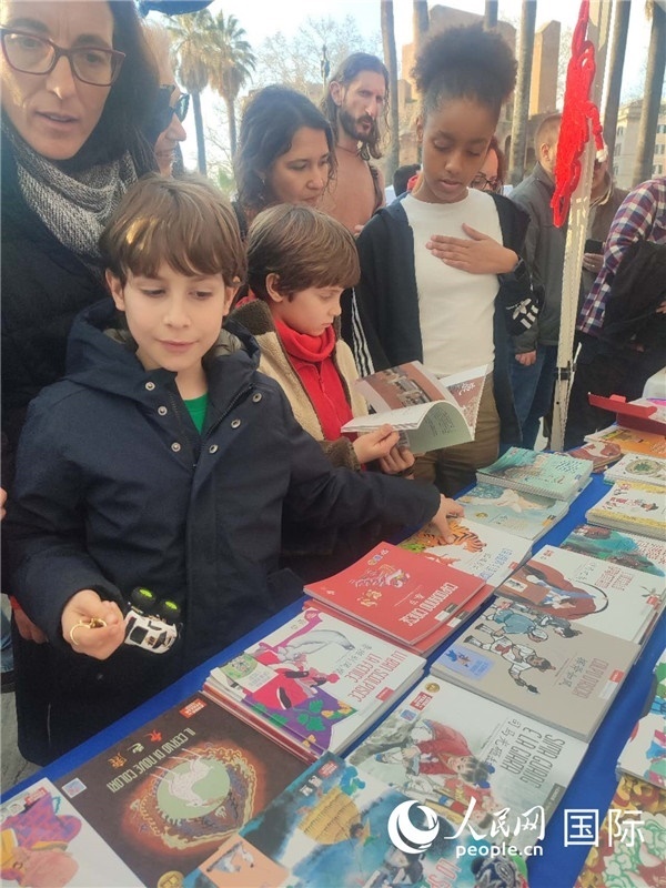 印刷精美的中國傳統(tǒng)文化叢書吸引了小游客的注意。人民網(wǎng)記者鄭彬攝