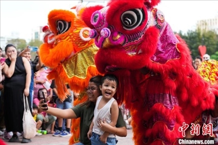 圖為舞獅表演吸引民眾合影。張興龍攝