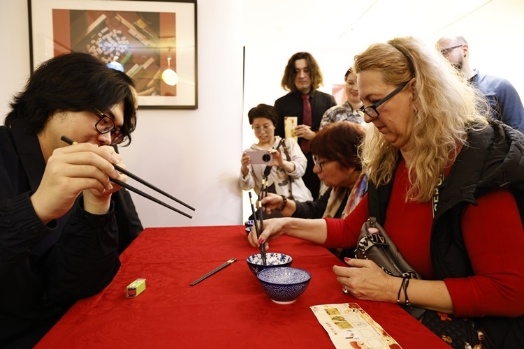 羅馬尼亞觀眾體驗用筷子夾花生。中國文化中心供圖