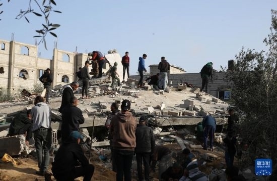  3月3日，在加沙地帶南部城市拉法，人們查看被以軍空襲破壞的建筑。新華社發(fā)（哈立德·奧馬爾攝）