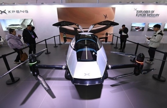 2023年12月1日，在鏈博會(huì)智能汽車鏈展區(qū)小鵬汽車展臺(tái)，參觀者觀看一臺(tái)智能飛行器。新華社記者蔡湘鑫攝