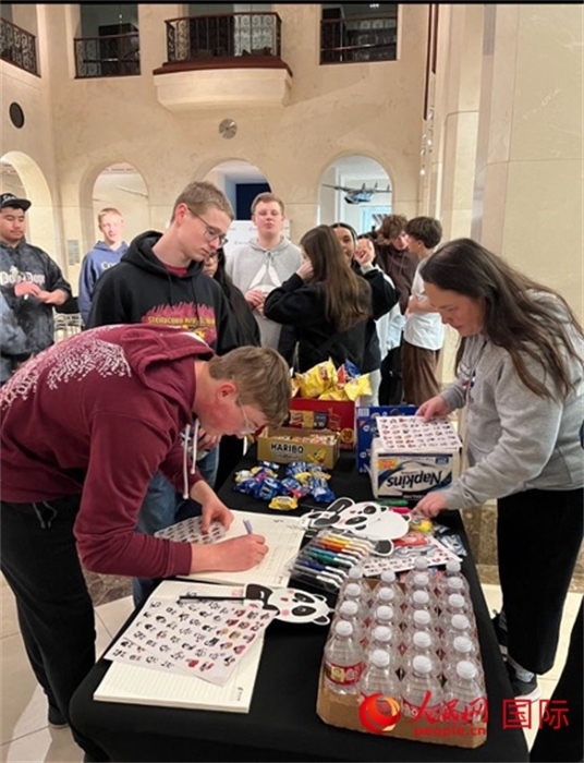 學生們出發(fā)前紛紛在留言簿留言。人民網(wǎng)記者 鄧圩攝