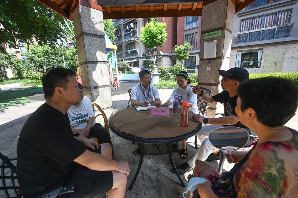 △2023年7月21日，在位于浙江杭州臨安區(qū)錦南街道水岸陽光小區(qū)的陽光議事廳，街道干部在聽取居民們反映的問題及意見。