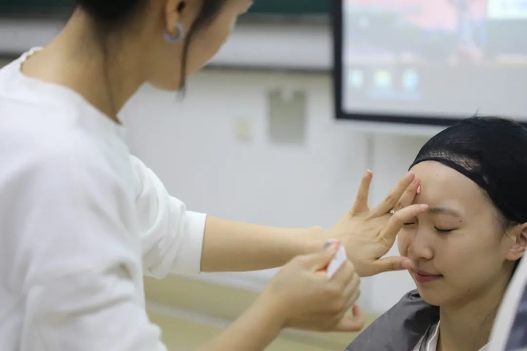 課堂上，一名學(xué)生在體驗(yàn)上戲妝。學(xué)校供圖