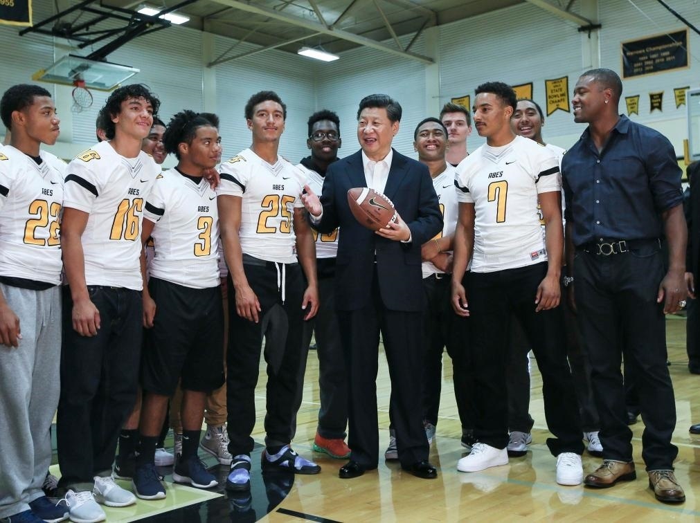 2015年9月23日，國家主席習近平參觀美國塔科馬市林肯中學。這是習近平在學校體育館，同上橄欖球訓(xùn)練課的學生們親切交談。新華社記者 蘭紅光 攝