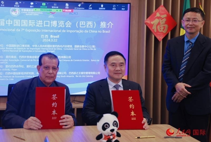 巴西外貿(mào)商會(huì)聯(lián)合會(huì)會(huì)長(zhǎng)阿代爾·羅伯托（左）與中國(guó)國(guó)際進(jìn)口博覽局副局長(zhǎng)吳政平（中）現(xiàn)場(chǎng)簽訂協(xié)議。人民網(wǎng)記者 宋亦然攝