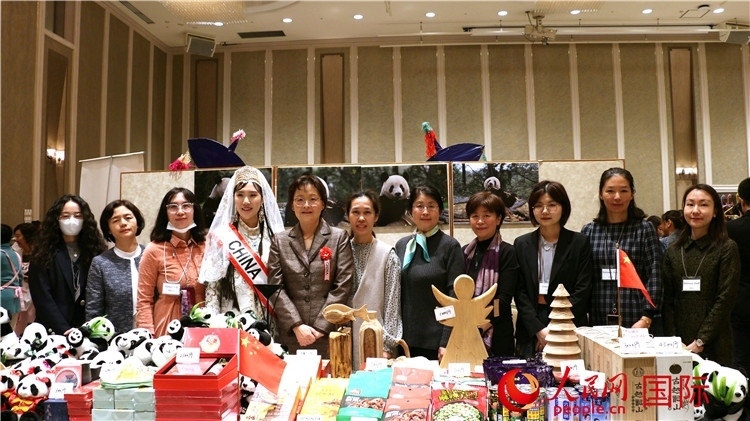 中國(guó)駐日本大使吳江浩夫人丁玥（左五）與使館人員在展位前合影留念。人民網(wǎng) 許可攝