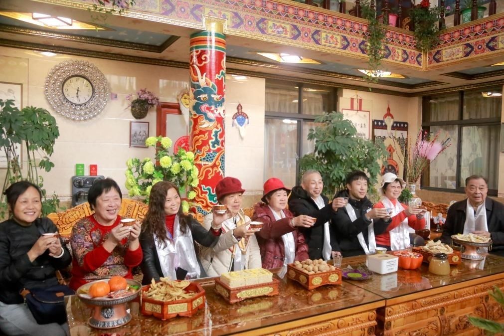 游客們?nèi)胱∶袼藓?，舉杯共飲酥油茶。新華社記者 邱星翔 攝