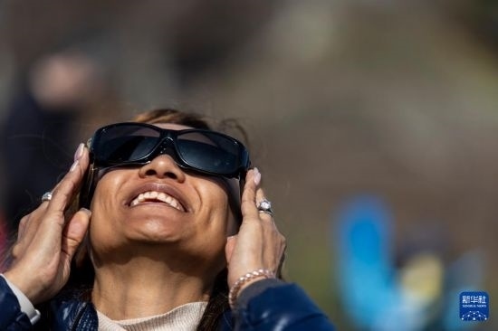4月8日，一名女子在美國(guó)紐約州普拉茨堡觀看日食。新華社發(fā)（文森特·約翰遜攝）