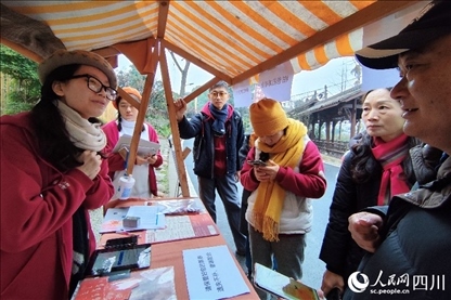 1月6日，“2024成都蒲江柑甜采摘節(jié)”上，記者見到了小萌（左一）和許多年輕人忙著做訪客接待、現(xiàn)場布置、票務(wù)核對、采摘服務(wù)等工作。人民網(wǎng)記者朱虹攝