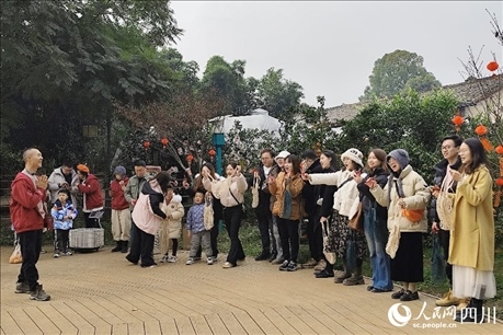 葉科（左一）給前來參與活動(dòng)的“柑爸柑媽”介紹生態(tài)種植果。人民網(wǎng)記者朱虹攝