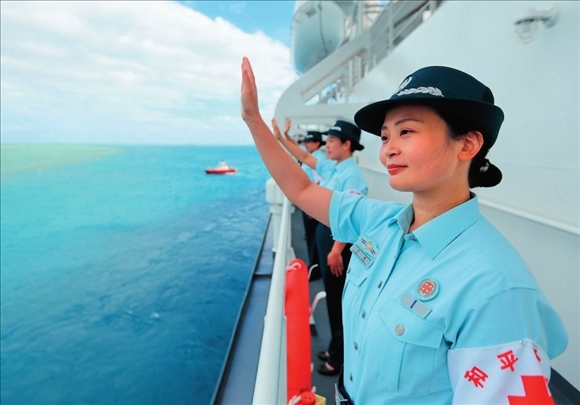 中國海軍“和平方舟”號(hào)醫(yī)院船結(jié)束訪問湯加時(shí)，任務(wù)官兵中的文職人員向歡送人群揮手告別（2023年8月4日攝）。徐巍攝/本刊