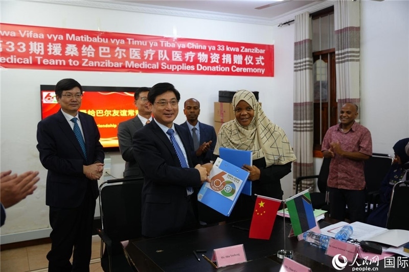 江蘇省蘇北人民醫(yī)院黨委書記束余聲與桑衛(wèi)生部首席秘書哈比巴交換捐贈書。中國援桑醫(yī)療隊(duì)供圖