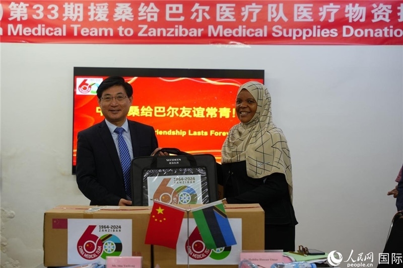 江蘇省蘇北人民醫(yī)院黨委書記束余聲捐贈物資與桑衛(wèi)生部首席秘書哈比巴。中國援桑醫(yī)療隊(duì)供圖