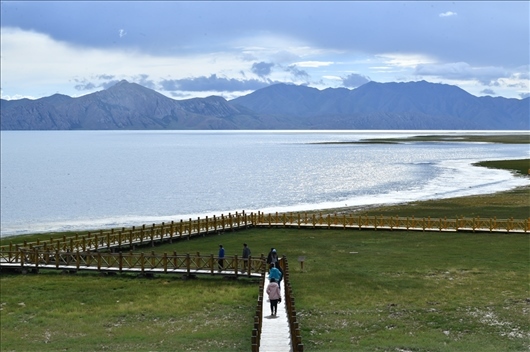 △ 游客行走在青?，敹嗫h冬格措納湖畔的木棧道上。