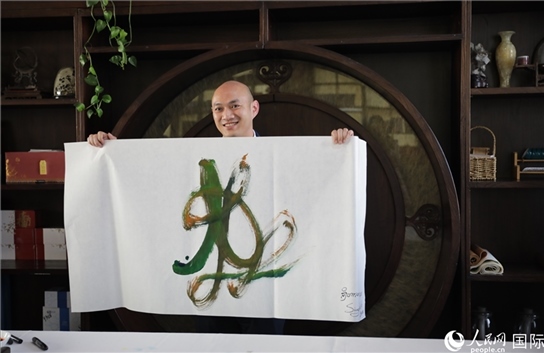 老撾駐華大使館三秘明君參加《五百筆·瀾湄合作》集體藝術創(chuàng)作。人民網王婧攝。