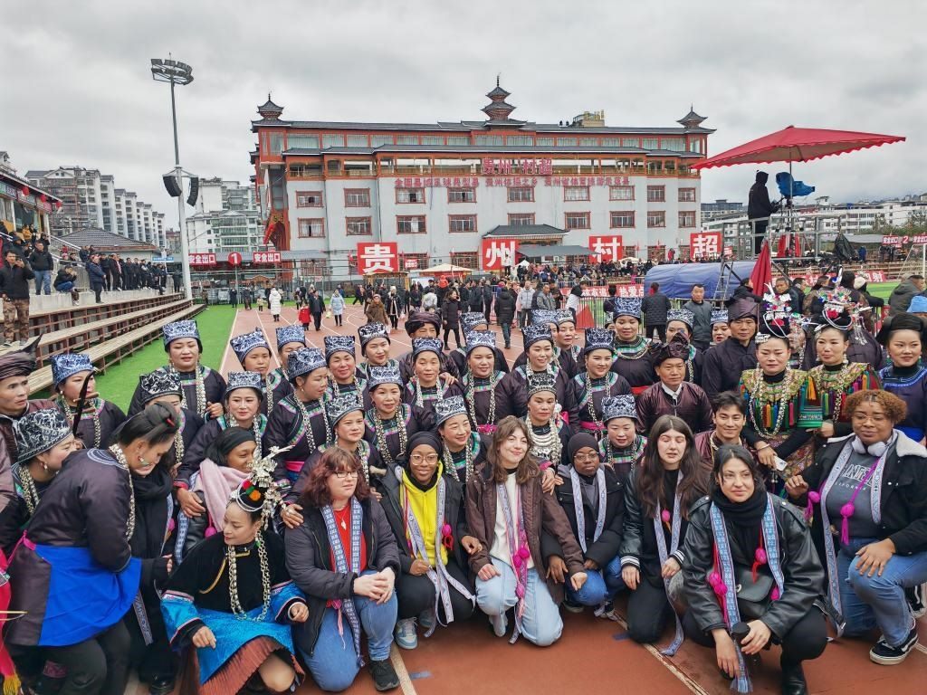 法國(guó)青年在“村超”賽場(chǎng)邊與參加表演的村民合影。新華社記者 羅羽 攝