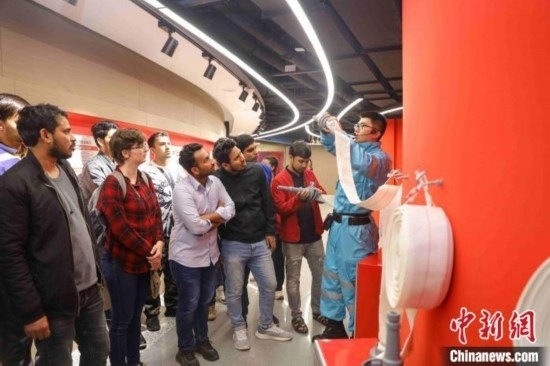 5月9日，工作人員指導(dǎo)留學(xué)生正確使用消防水帶。張鷹 攝