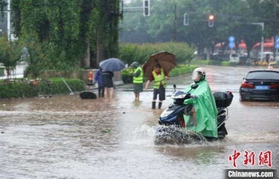5月10日，廣西沿海遭遇強(qiáng)降雨。圖為欽州市民眾在積澇中出行。陸敏 攝