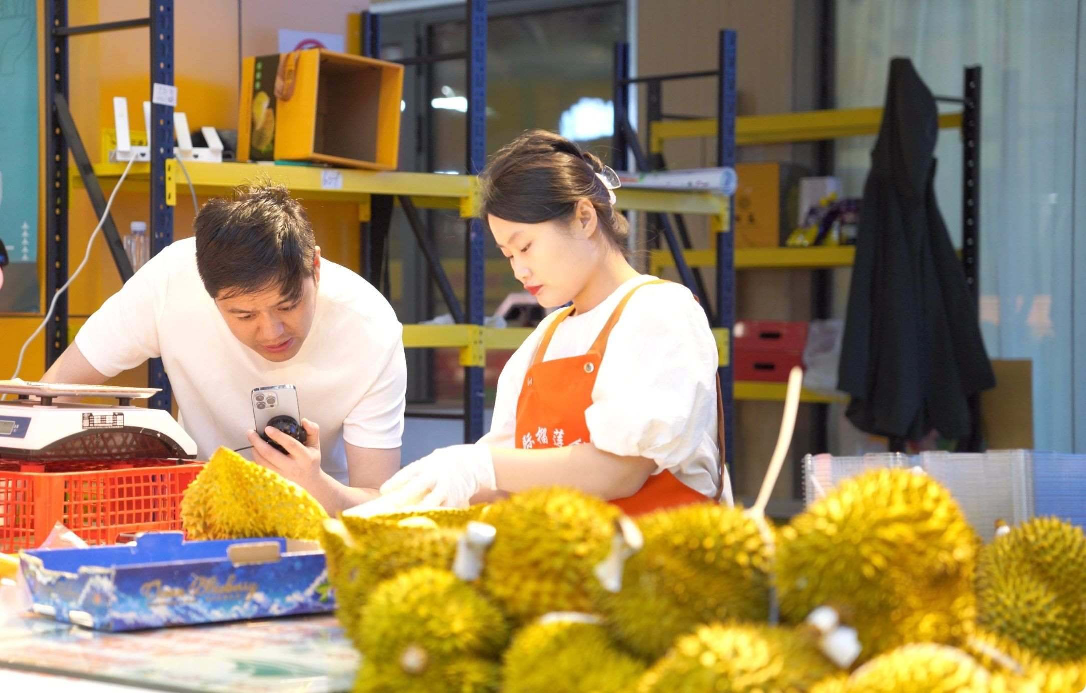 榴蓮商家正在通過(guò)手機(jī)直播銷(xiāo)售榴蓮。人民網(wǎng)記者申佳平 攝