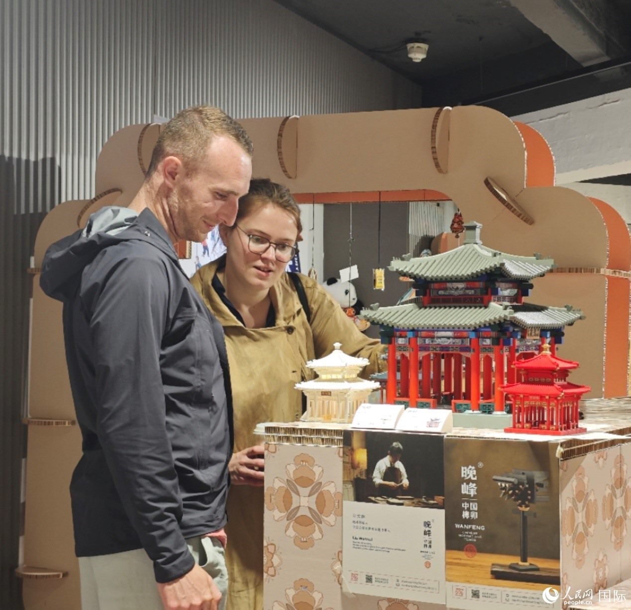 英國觀眾在欣賞中國傳統(tǒng)榫卯結構建筑模型。邢雪攝