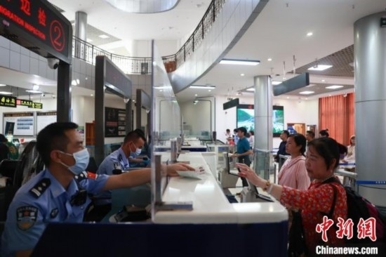 圖為旅客在磨憨口岸辦理通關(guān)手續(xù)。雷雨 攝