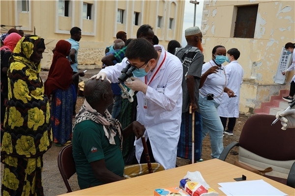 在義診現(xiàn)場(chǎng)，中國(guó)醫(yī)生與當(dāng)?shù)鼐用窈嫌傲裟?，吉布提鹽業(yè)投資公司供圖