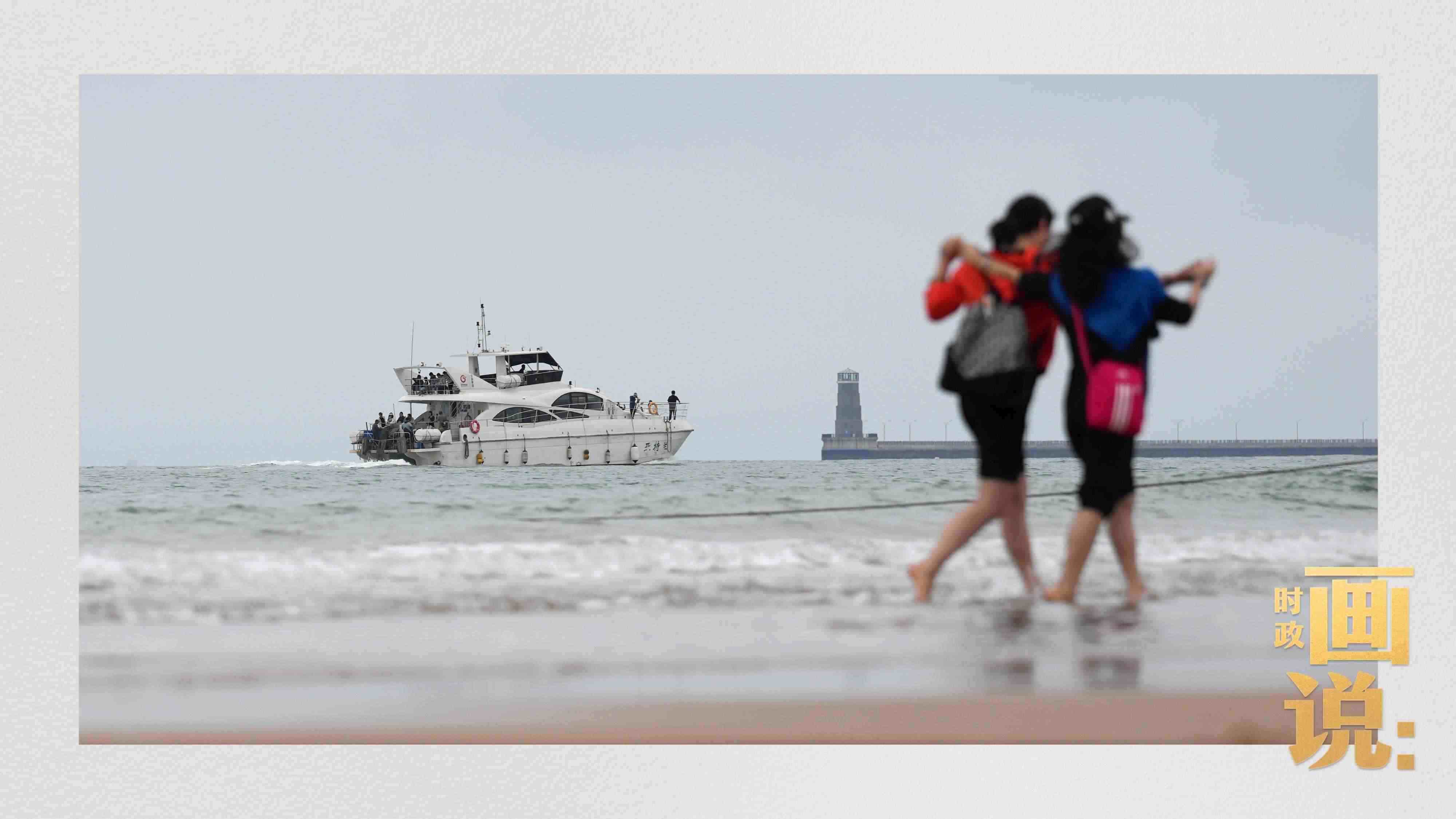 △日照陽光海岸綠道上的萬平口景區(qū)，一對游客在海浪中翩然起舞。