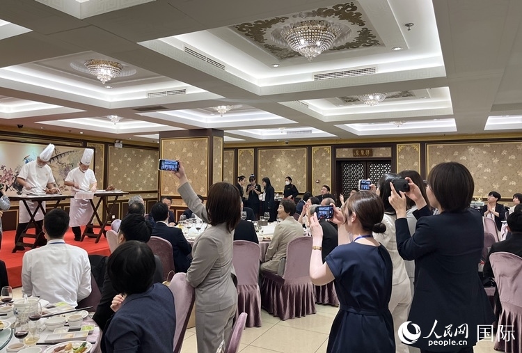 國家級非物質(zhì)文化遺產(chǎn)、全聚德片鴨工藝吸引代表團(tuán)成員拍照留念。