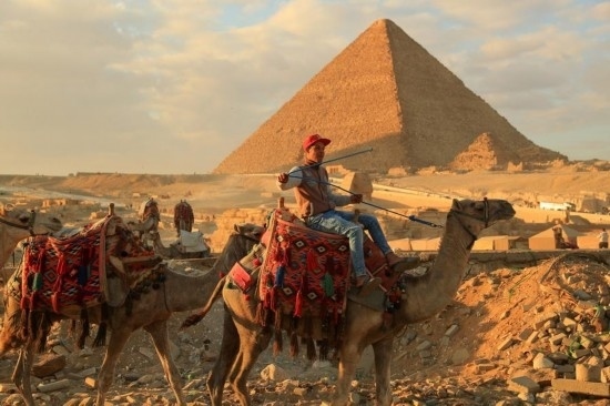 1月24日，商販騎駱駝離開埃及吉薩金字塔景區(qū)。新華社記者 隋先凱 攝