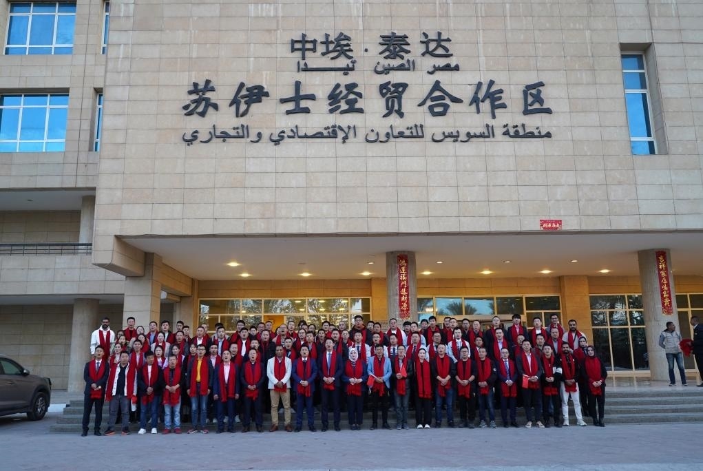 2024年2月11日，在位于埃及蘇伊士省的中?！ぬ┻_(dá)蘇伊士經(jīng)貿(mào)合作區(qū)，中埃員工在合作區(qū)辦公大樓前合影拜年。新華社發(fā)（泰達(dá)合作區(qū)供圖）