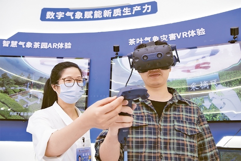 2024年5月23日，第七屆數(shù)字中國(guó)建設(shè)峰會(huì)現(xiàn)場(chǎng)體驗(yàn)區(qū)在福州海峽國(guó)際會(huì)展中心向?qū)I(yè)觀眾開(kāi)放。本次現(xiàn)場(chǎng)體驗(yàn)區(qū)圍繞本屆峰會(huì)主題“釋放數(shù)據(jù)要素價(jià)值，發(fā)展新質(zhì)生產(chǎn)力”，設(shè)置“數(shù)字惠民”、“數(shù)字能力”、“數(shù)字基礎(chǔ)”、“數(shù)字生態(tài)”、“數(shù)字賦能”五大板塊。圖為一名觀眾（右）在數(shù)字氣象賦能新質(zhì)生產(chǎn)力展臺(tái)上進(jìn)行體驗(yàn)。 新華社記者 魏培全/攝