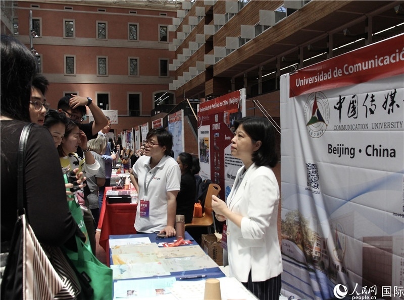 旅西華人華僑在展臺前咨詢。人民網(wǎng)記者 許海林?jǐn)z