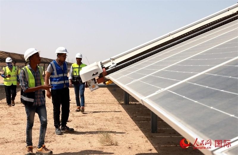 工作人員在測試自動(dòng)清掃機(jī)器人。人民網(wǎng)記者管克江攝