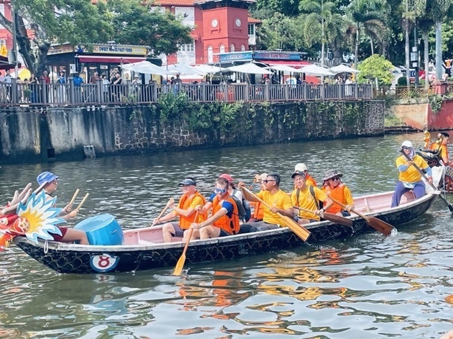 多元種族共同奮輯前進，體驗在馬六甲河劃龍舟，引來大批游客駐足圍觀。組委會供圖