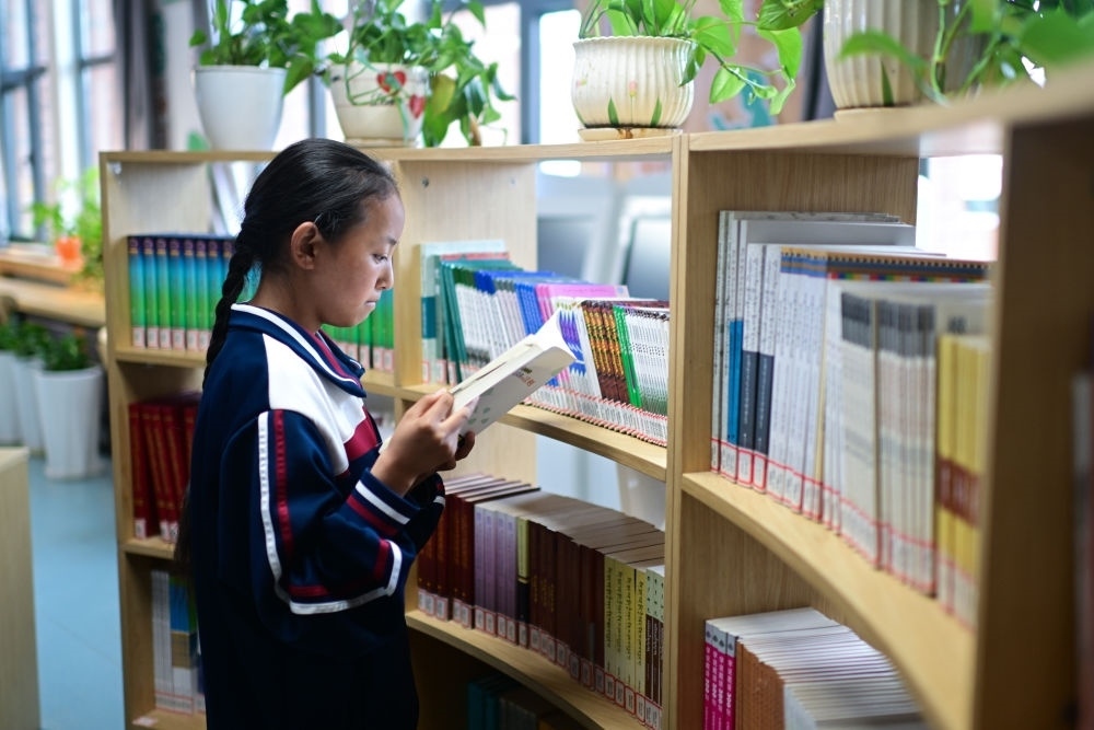 6月18日，果洛西寧民族中學(xué)學(xué)生尼東拉毛在圖書室看書。