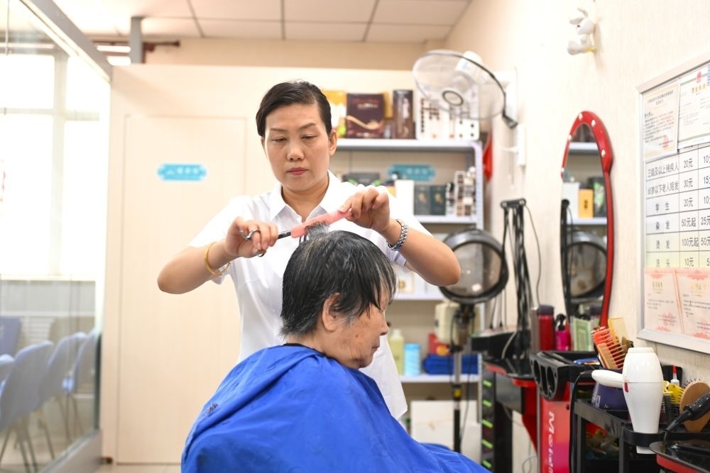 6月20日，長(zhǎng)城花園社區(qū)的志愿者為居民理發(fā)。