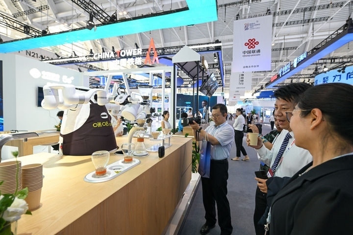 6月20日，與會(huì)者品嘗機(jī)器人沖調(diào)出的咖啡。新華社記者 孫凡越 攝