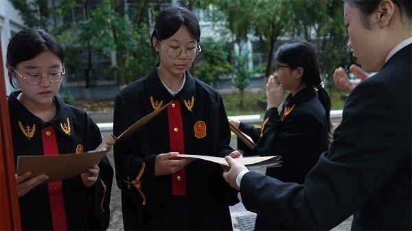 圖①：武平法院干警向?qū)W生分發(fā)道具卷宗。