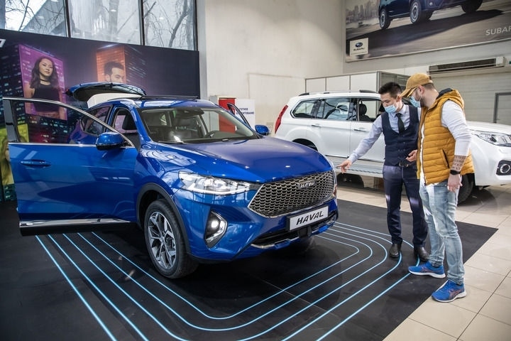 2021年4月1日，銷售人員在哈薩克斯坦阿拉木圖市經(jīng)銷商店向消費(fèi)者介紹哈弗汽車。新華社發(fā)（阿斯塔納汽車公司供圖）