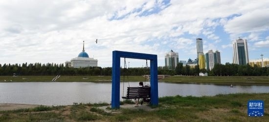 6月30日，一名女子在哈薩克斯坦首都阿斯塔納伊希姆河畔休息。新華社記者 王建華 攝